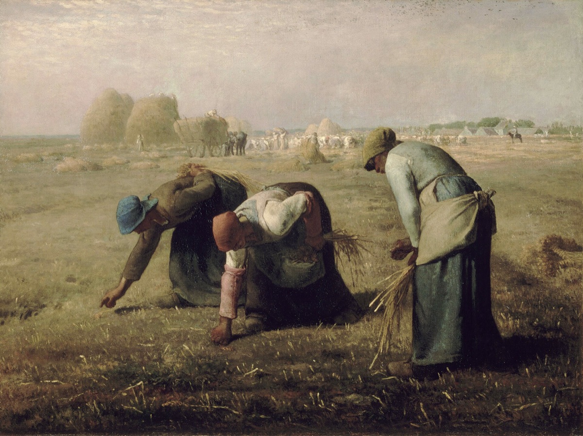 Three women bending to glean the leftover grain at the edge of a harvested field